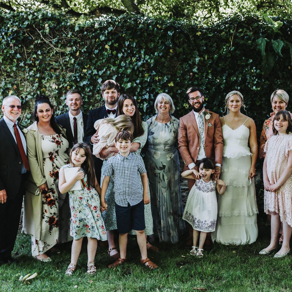 Wedding party gather for photos outdoors with one another at Treseren in Cornwall 
