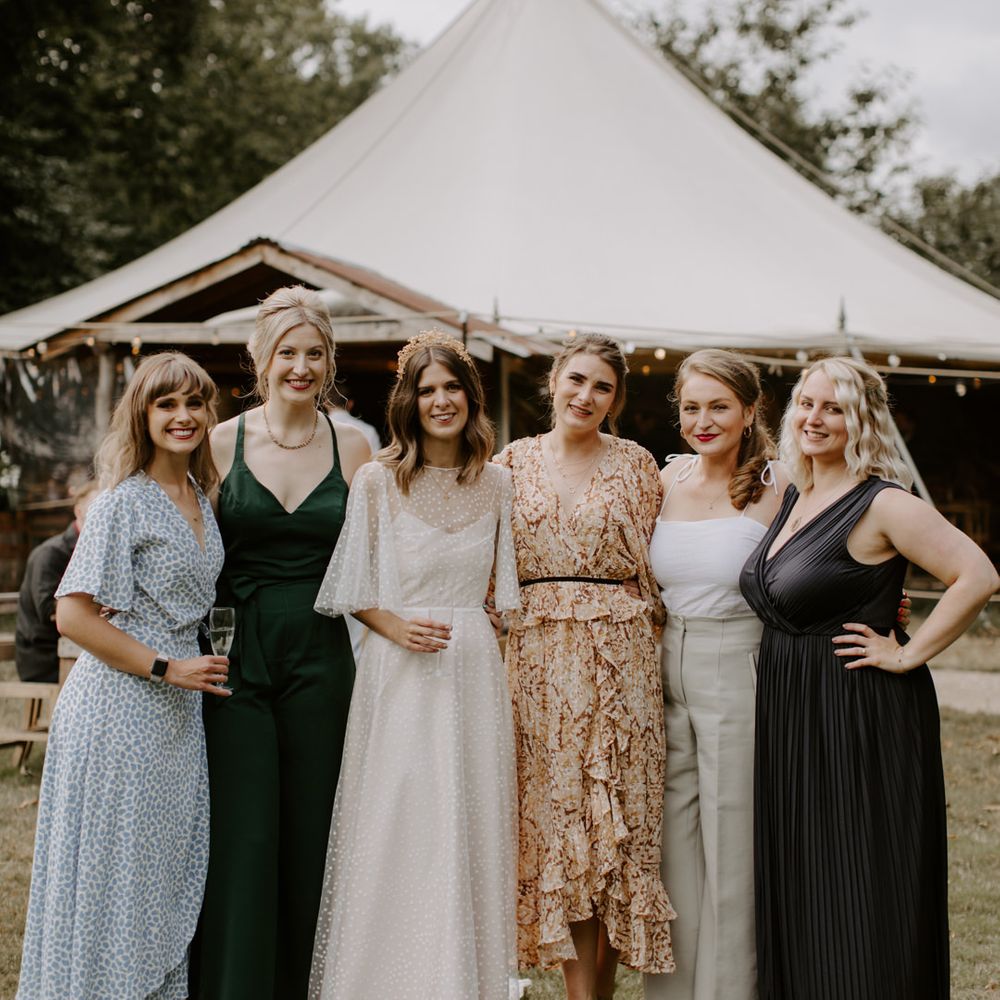 Bride stands with her wedding guests on her wedding day outdoors