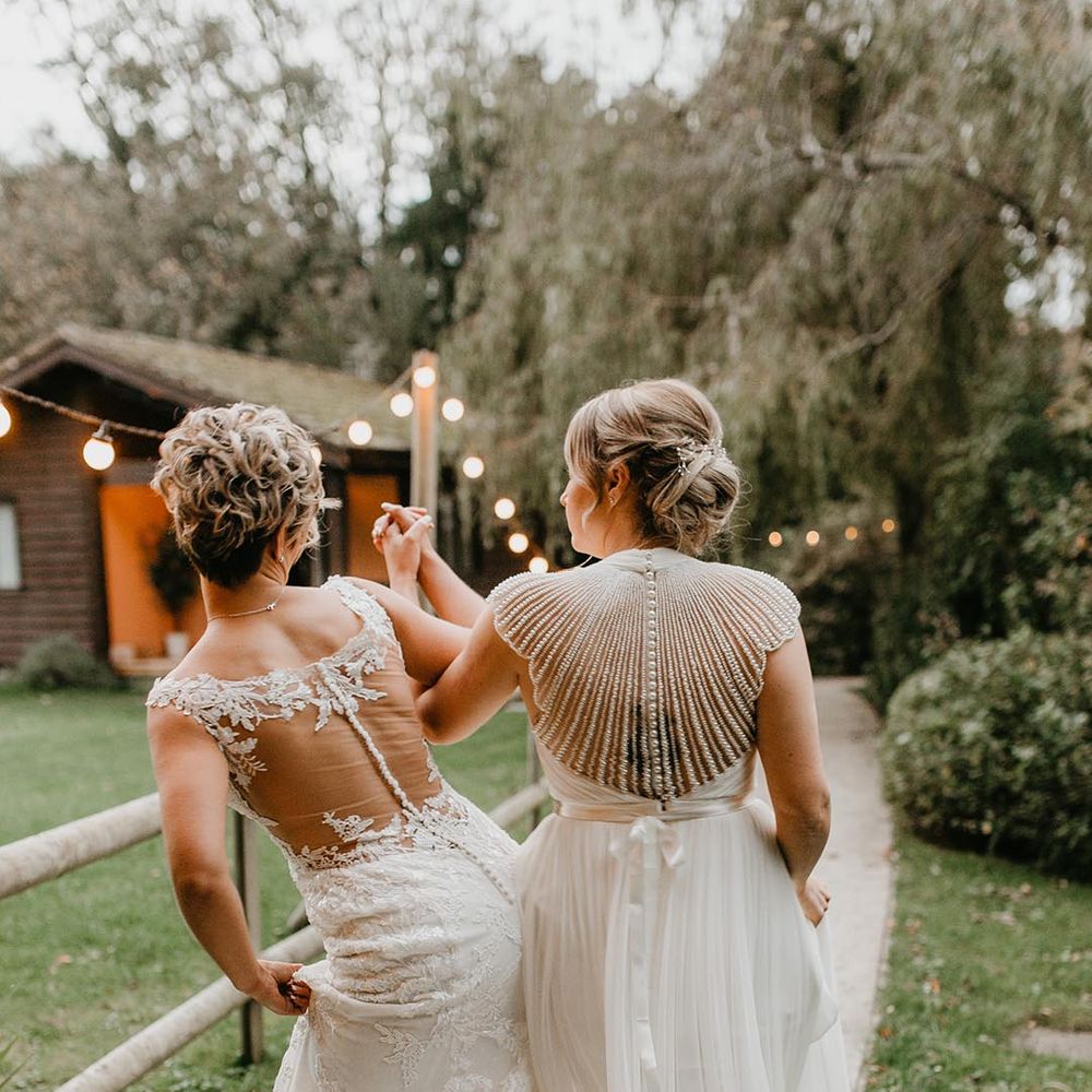 Lesbian wedding with two brides in an illusion back with lace and embellished wedding dress designs 