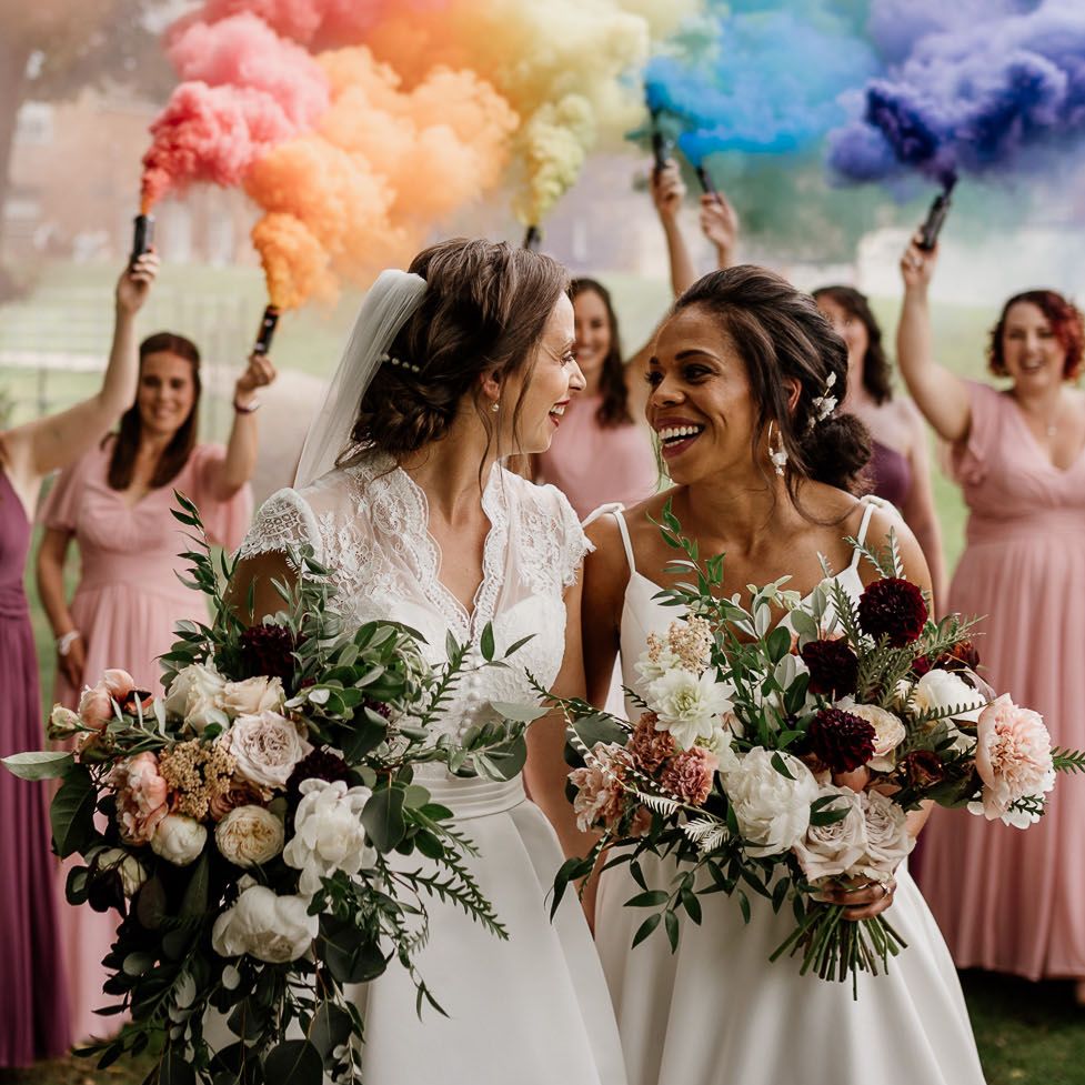 Smoke bomb portrait at Lesbian wedding with two brides holding oversized white and burgundy bouquets 