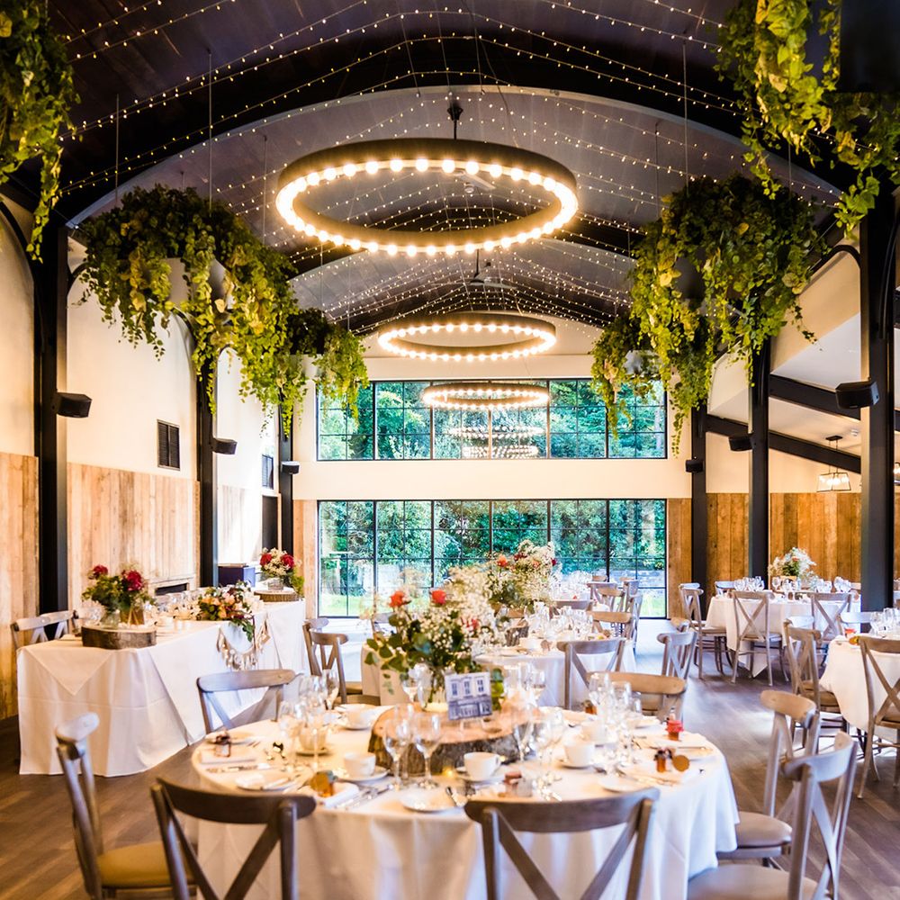 Reception area with grey chairs, tree trunk centrepieces and decorative greenery