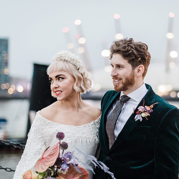 Bride and groom smile as they look over views of Millennium Dome and London