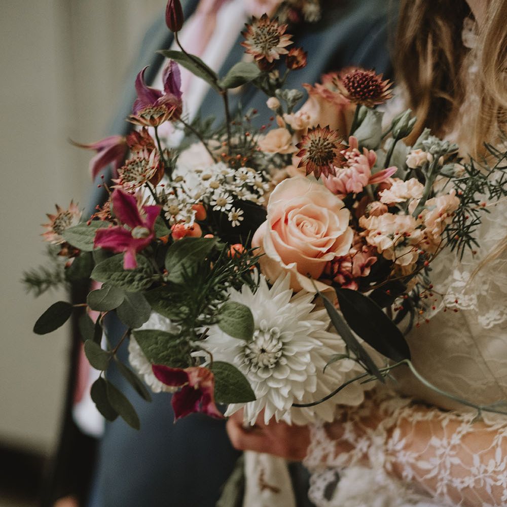 Sustainable floral bouquet with white roses and green foliage tied with personalised white ribbon