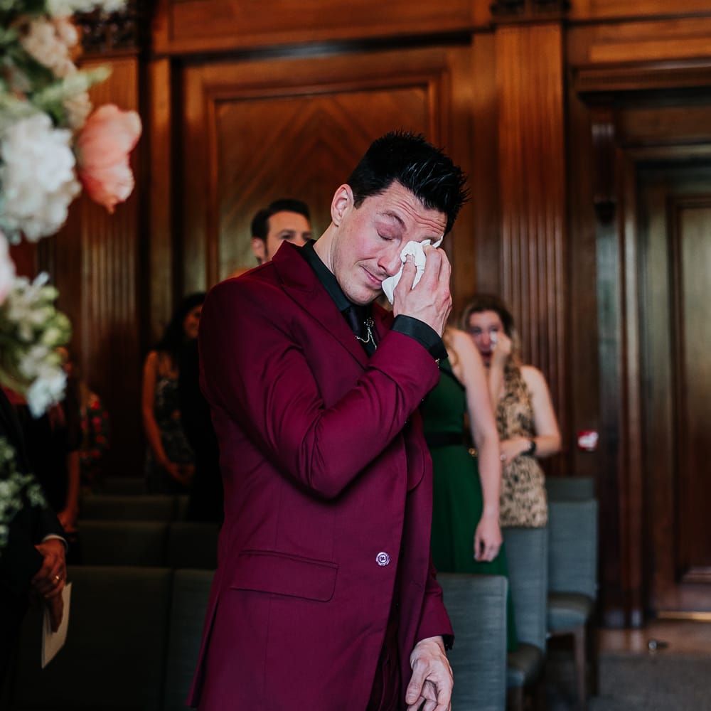 Bride hugs her groom during ceremony at The Old Marylebone Town Hall on their wedding day
