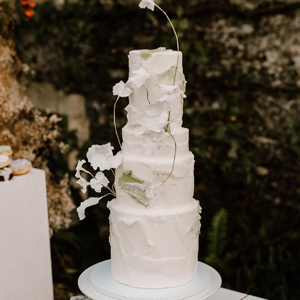 Four tier white wedding cake with texture and flower decoration 