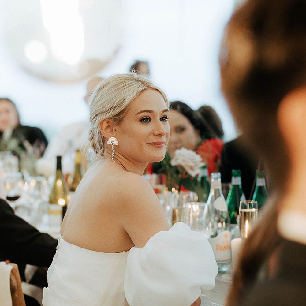 Blonde bride wears statement earrings and puffed sleeve Jesus Peiro wedding dress 