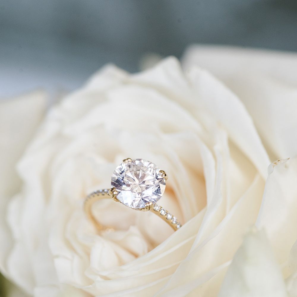 Round brilliant diamond engagement ring on diamond and gold band 