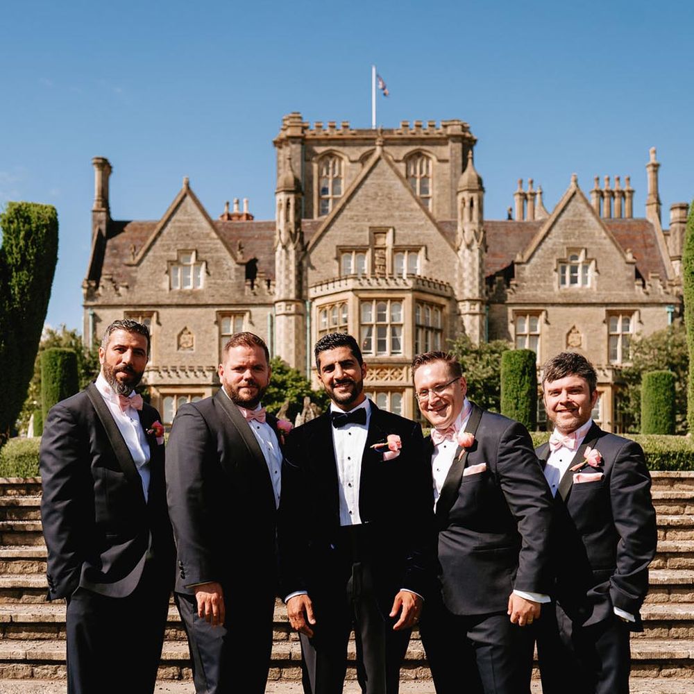Groom and groomsmen in black tie pose together at the De Vere Tortworth Court wedding 