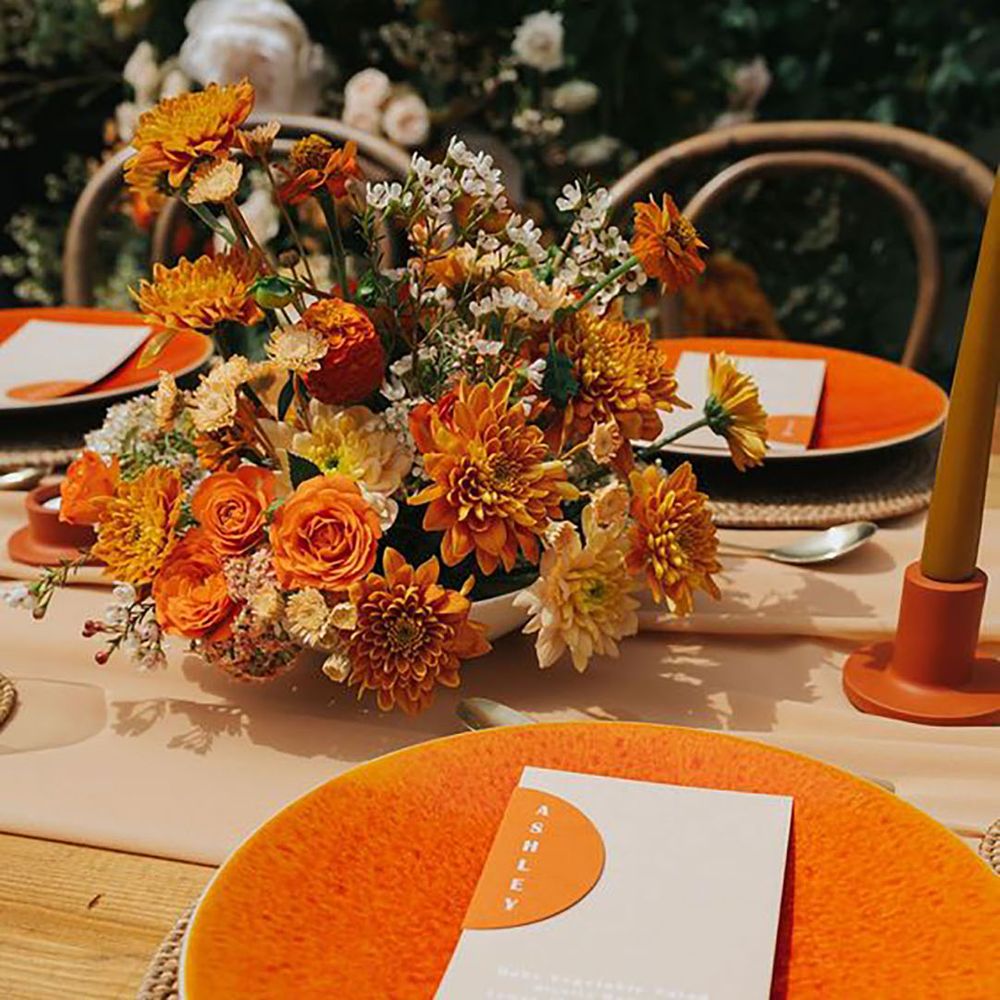 Orange tablewear and decor including plates and flowers by Annie Poe Photography 