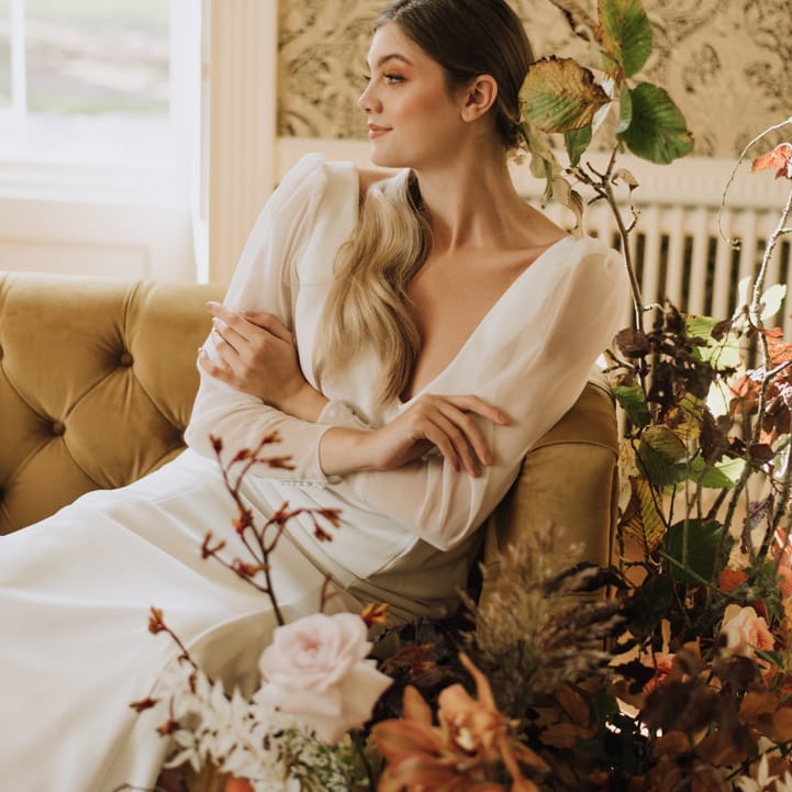 Bride wears sheer long sleeve wedding dress with button cuff details