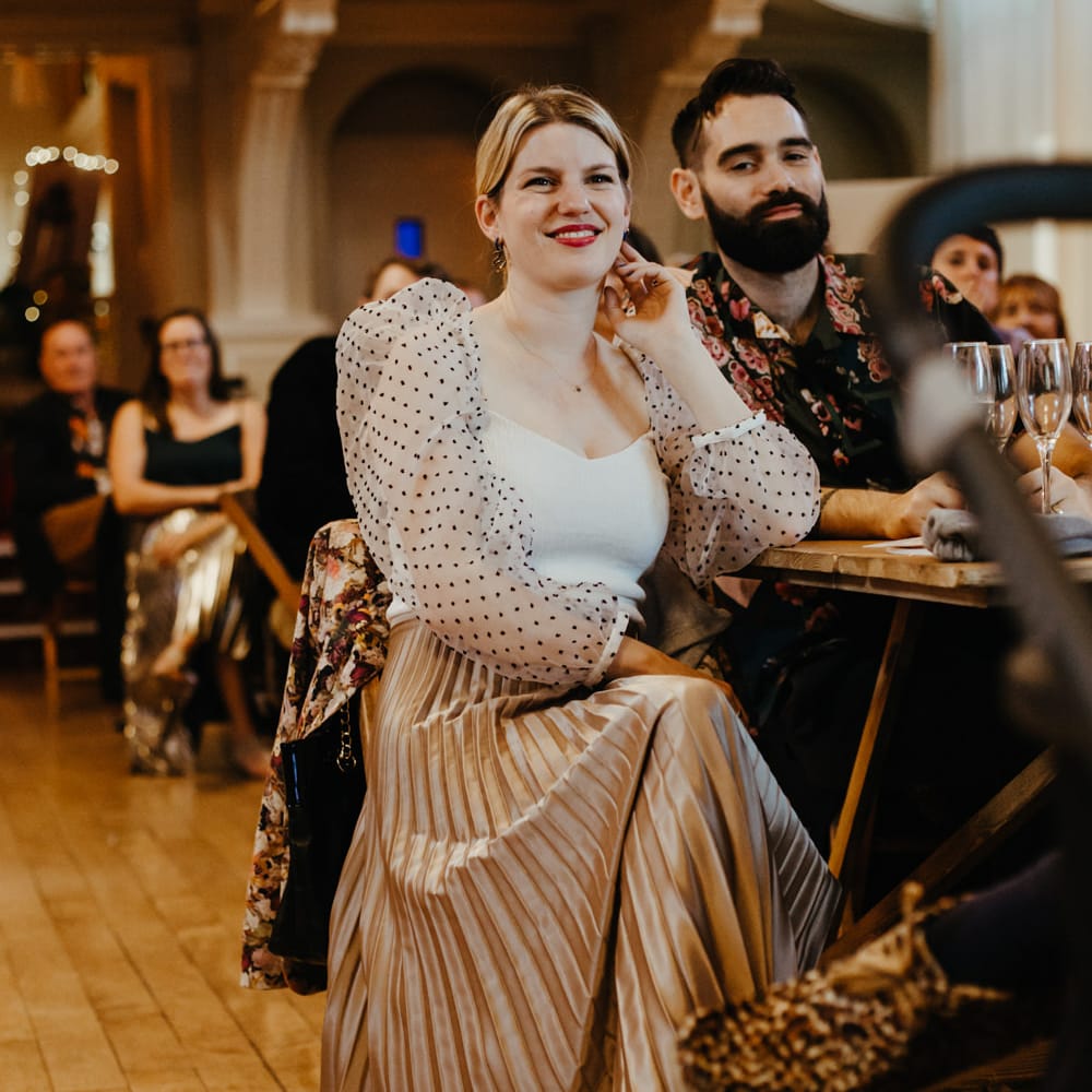 Stylish wedding guest in champagne pleated skirt and polka dot blouse 