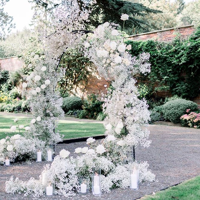 White gypsophila and rose floral arch with pillar candles 