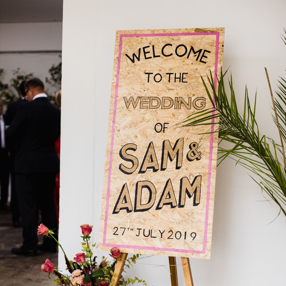 Contemporary chipboard wedding sign and bright wedding flowers