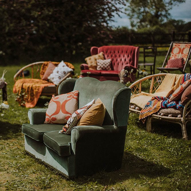 outdoor sixties wedding with retro furniture seating, cushions and rugs 
