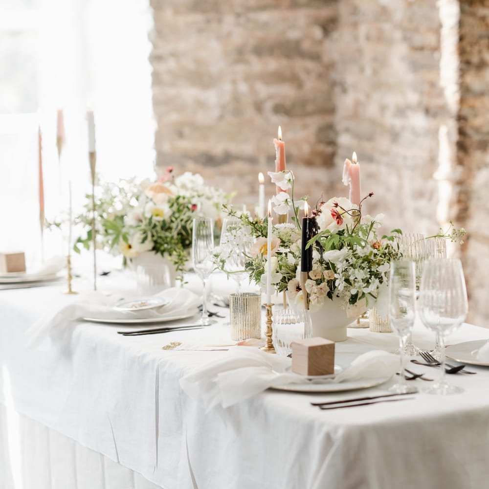 elegant wedding table decor with pastel wedding flowers and pink taper candles in gold candlesticks 