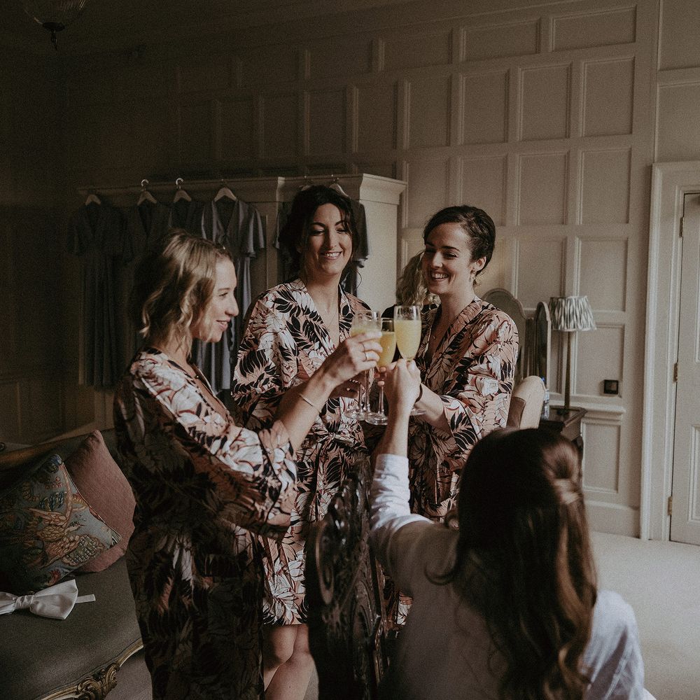Bridesmaids get ready on the morning of wedding as they wear matching floral dressing gowns
