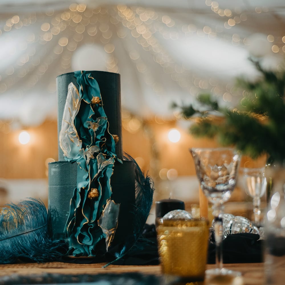 Two tier blue wedding cake with ripple decoration and rustic wedding decor at The Wellbeing Farm wedding in Lancashire