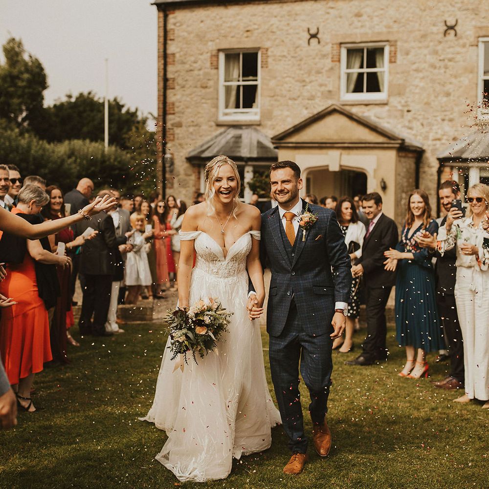 Bride and groom confetti exit at East Afton Farmhouse wedding