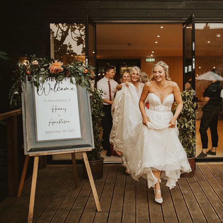 Bride in strapless wedding dress leads wedding guests outside
