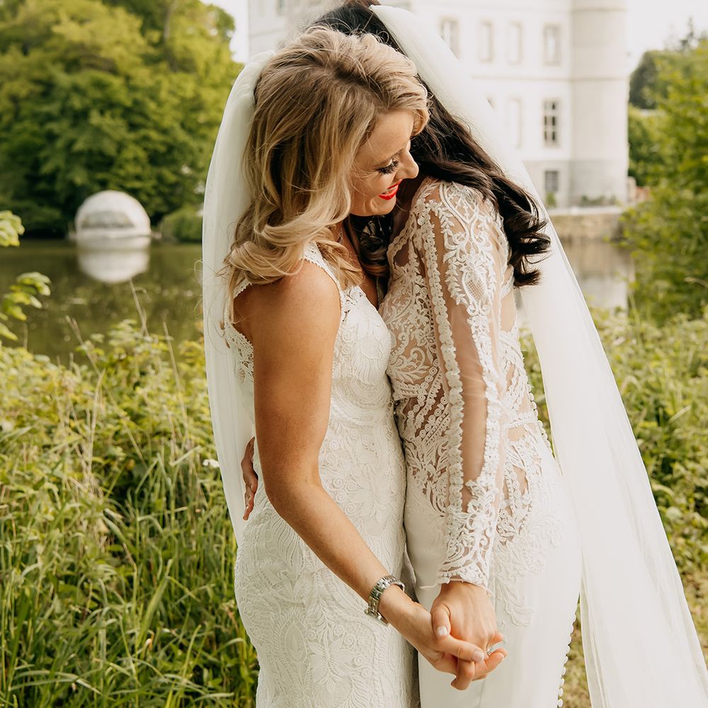 Brides share an intimate embrace on their wedding day 