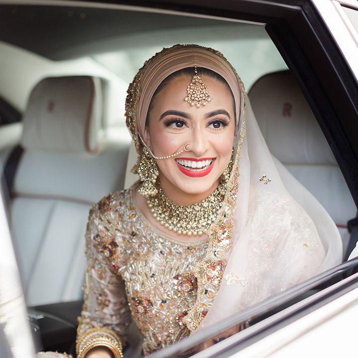 Bride wears red lipstick and smiles on her wedding day in wedding car 