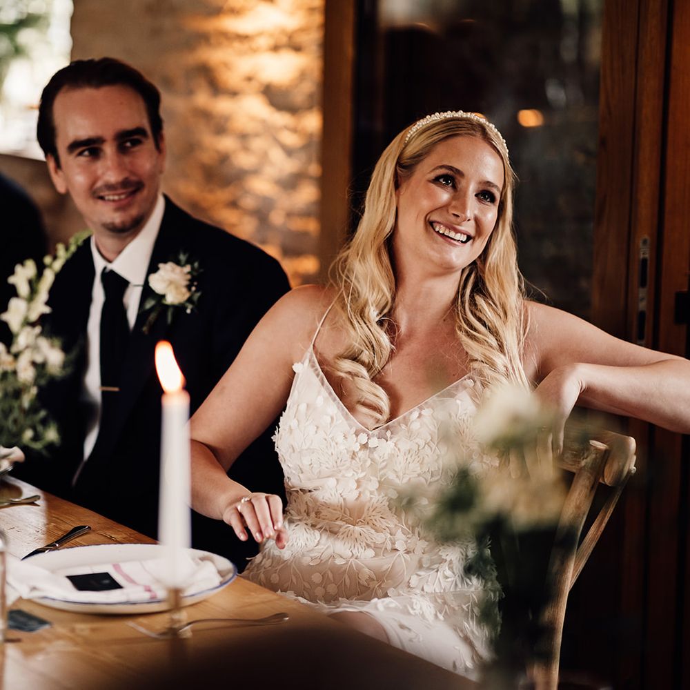 Bride and groom sit down for their wedding reception and listen to the speeches 