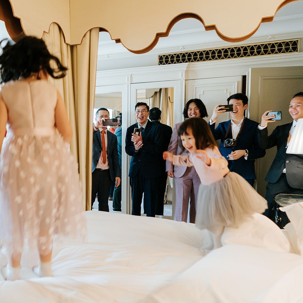 Flower girls jump on bed during wedding day at The Dorchester 