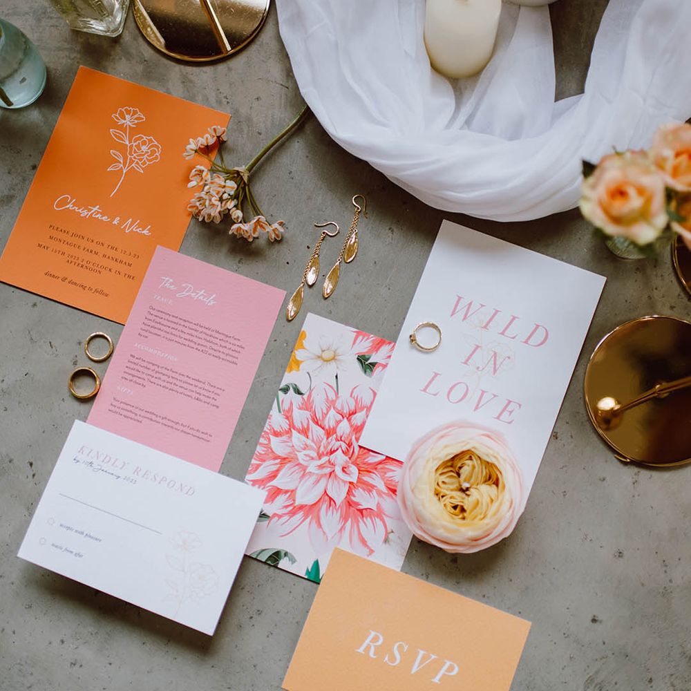Orange white and pink simplistic wedding stationery with white tulle table runners and pillar candles 