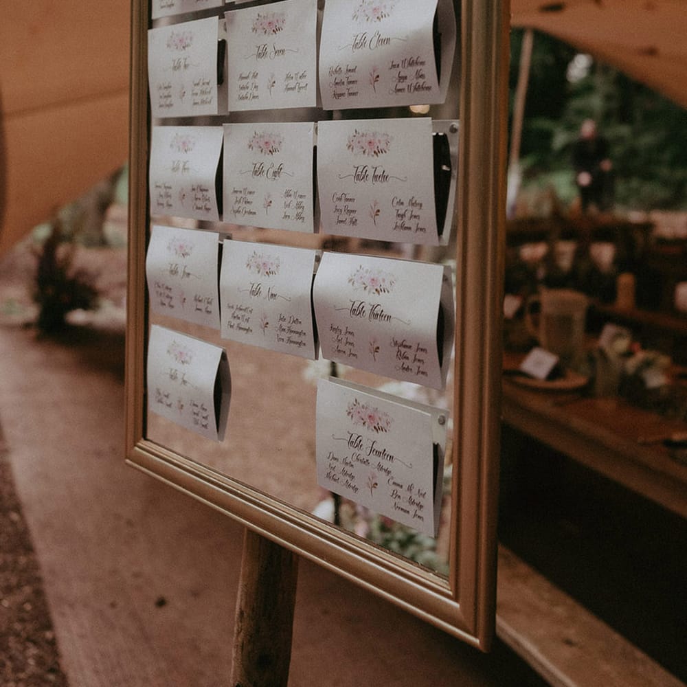 Mirror wedding seating chart signage with cards for each table 