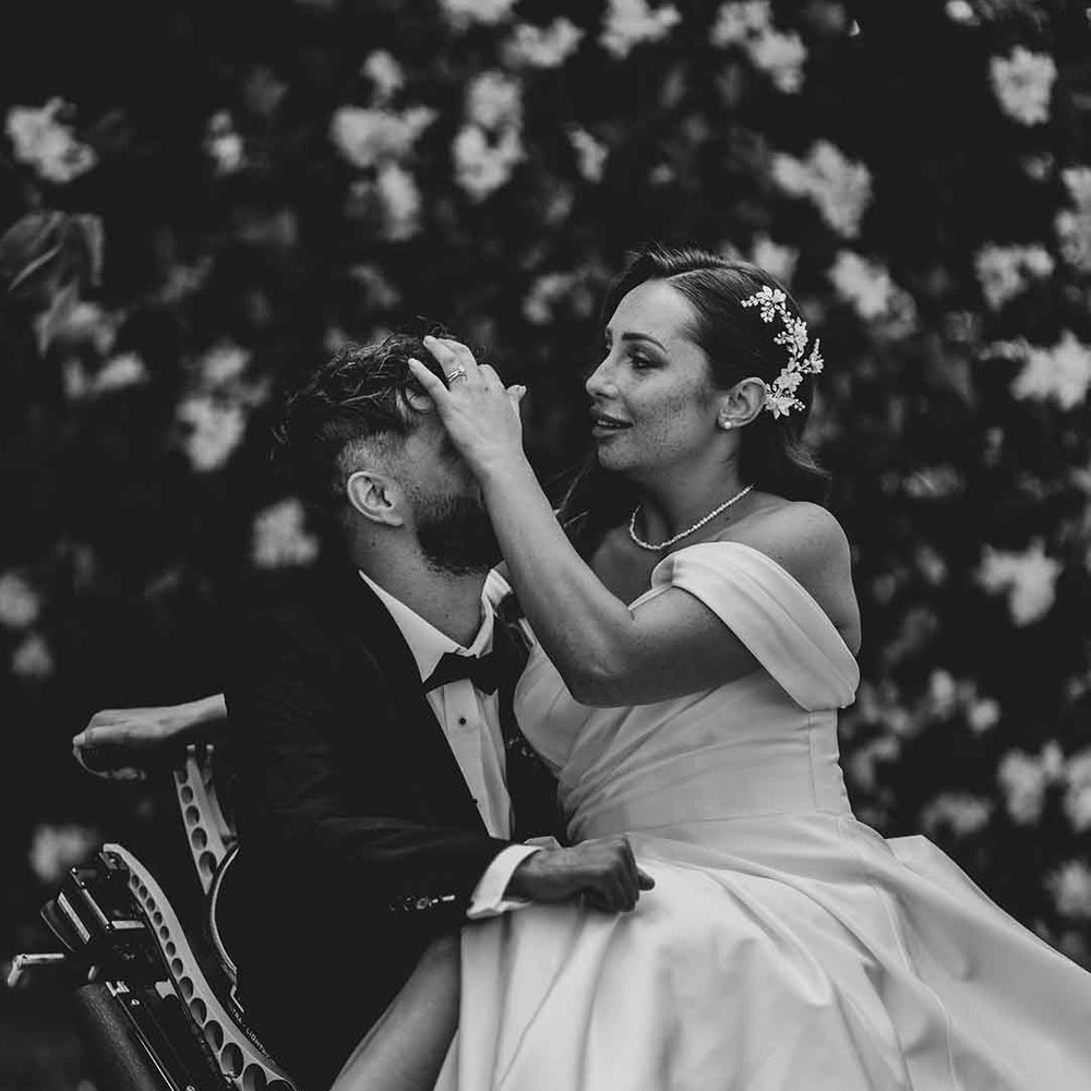 inter able couple at Capesthorne Hall wedding with bride in a front slit wedding dress and bow shoes 