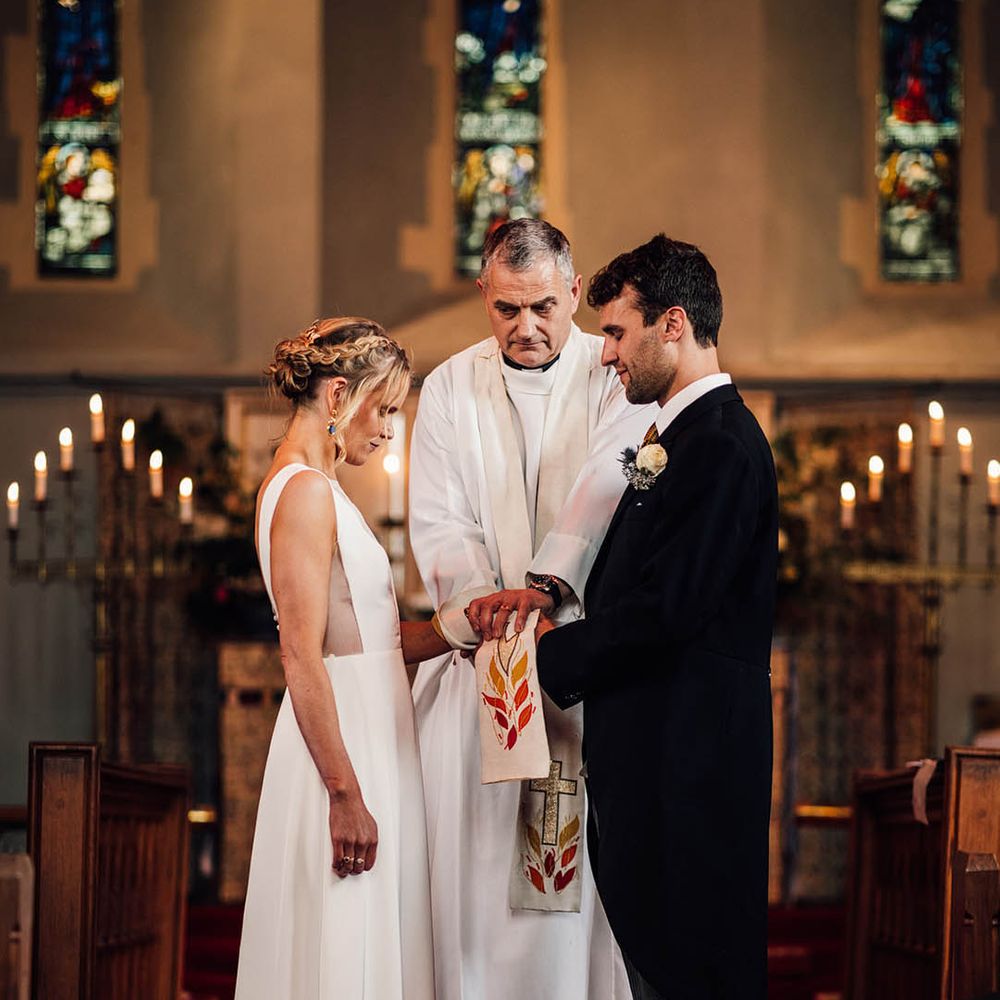 The bride and groom participate in their religious church wedding in Wales 