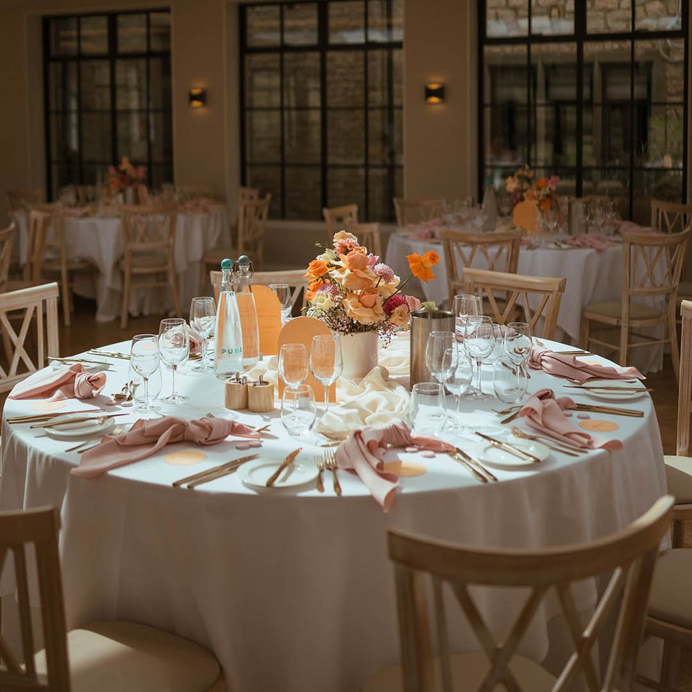 Stunning baby pink and orange wedding tablescape with hanging flower cloud installation