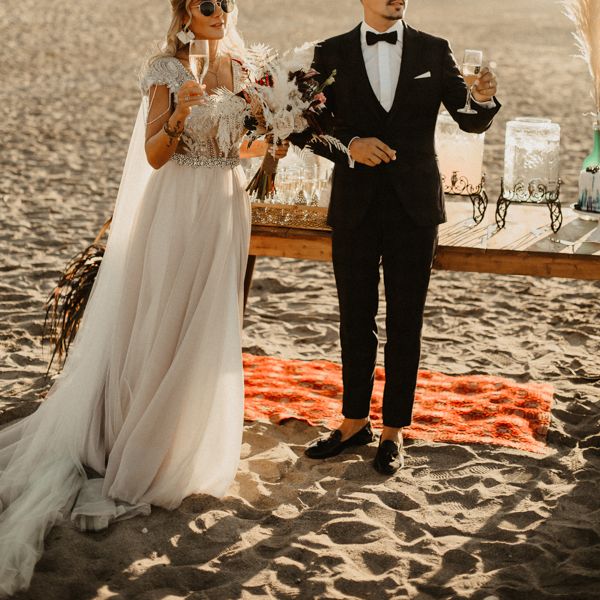 Bride and groom raise a toast at beach wedding in Crete