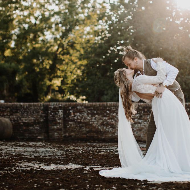 Groom holding his bride for romantic garden wedding photography