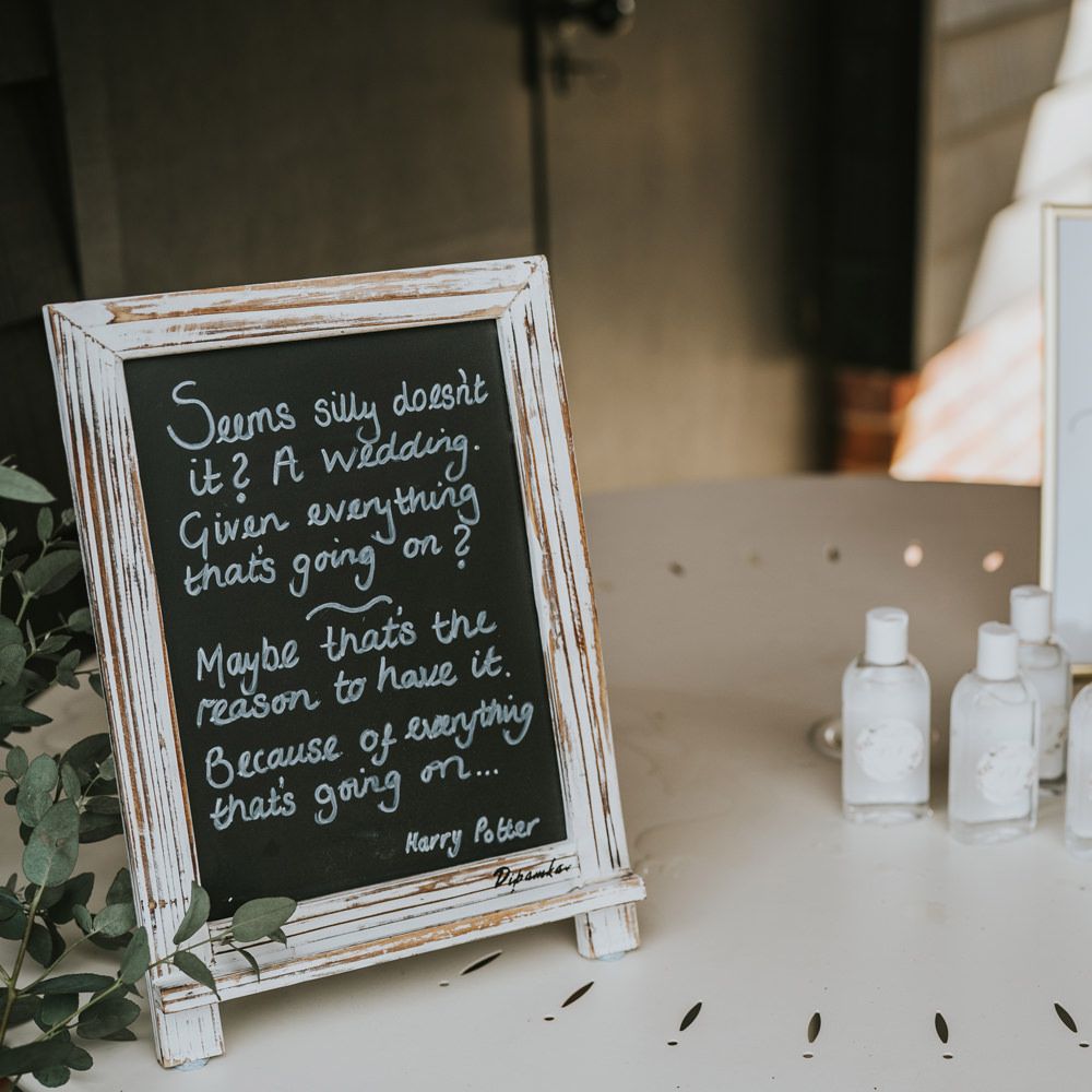 Hand sanitiser next to chalk wedding sign of Harry Potter quote  