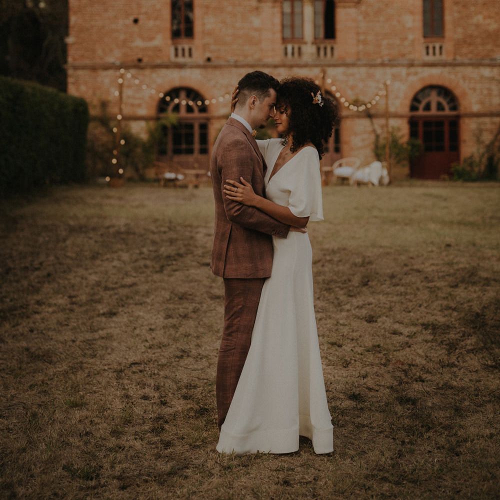Bride and groom portrait outside a French Castle with festoon light decor 