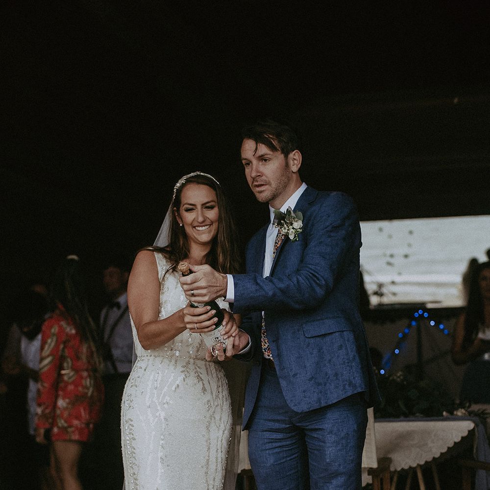 Bride & groom celebrate with champagne after wedding ceremony on the beach 