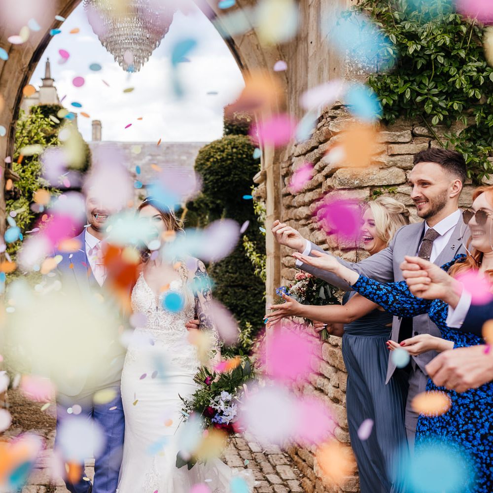 Bride & groom walk through confetti 