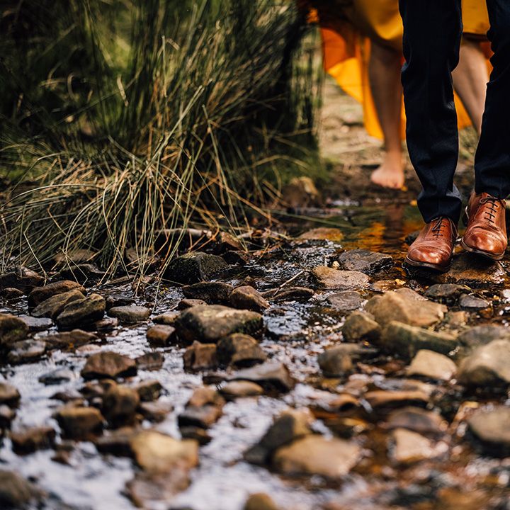 Bride & grooms feet against rocks outdoors 