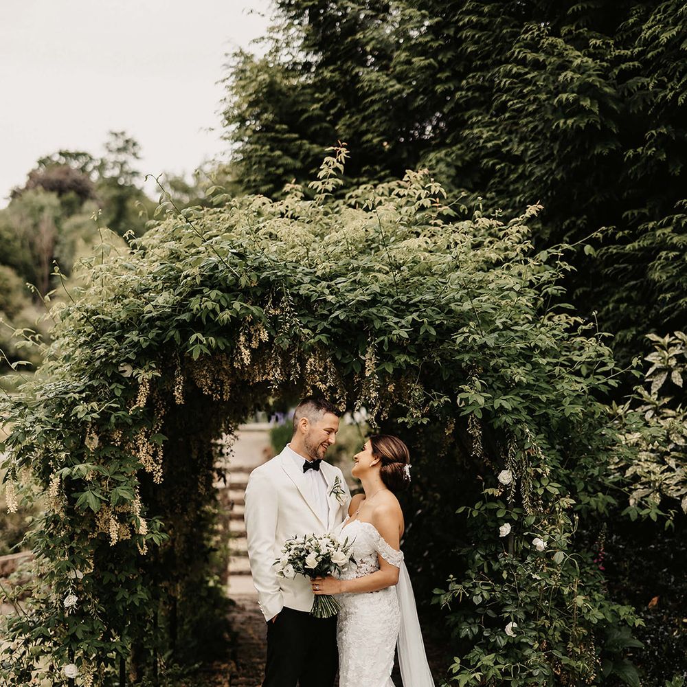 The bride and groom gaze into each other's eyes as they pose for their couple portraits in the grounds at The Orangery in Kent 