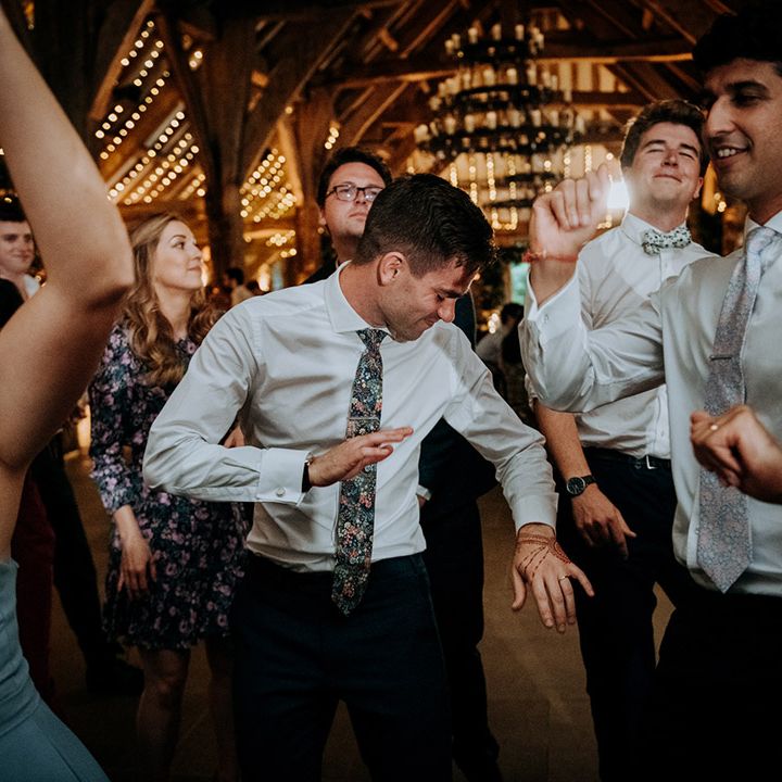 Grooms dance with friends and family during wedding reception at The Tithe Barn Bolton Abbey