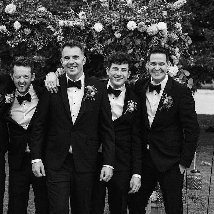 Groomsmen in matching black tuxedos with the groom for wedding party photo at Culden Faw Estate 