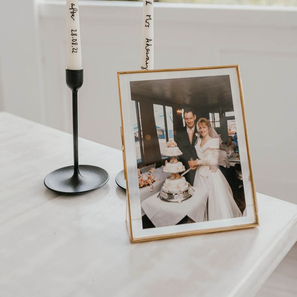 Family photo of family wedding in gold photo frame with personalise white taper candles 