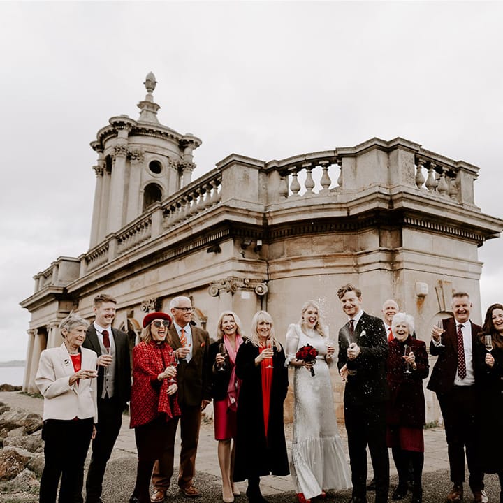 The wedding party pops champagne in front of the Normanton Church 