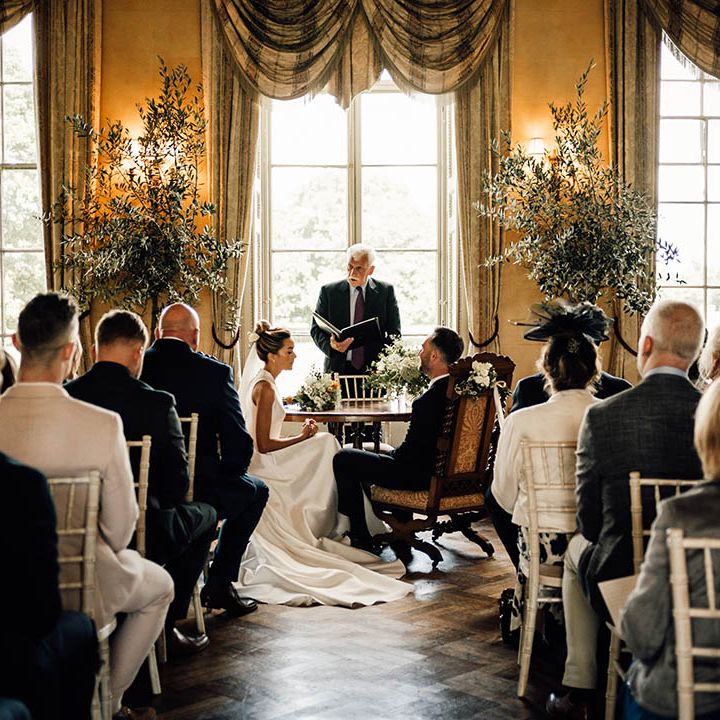 The bride and groom stand at the altar for their Hampton Court House wedding ceremony 