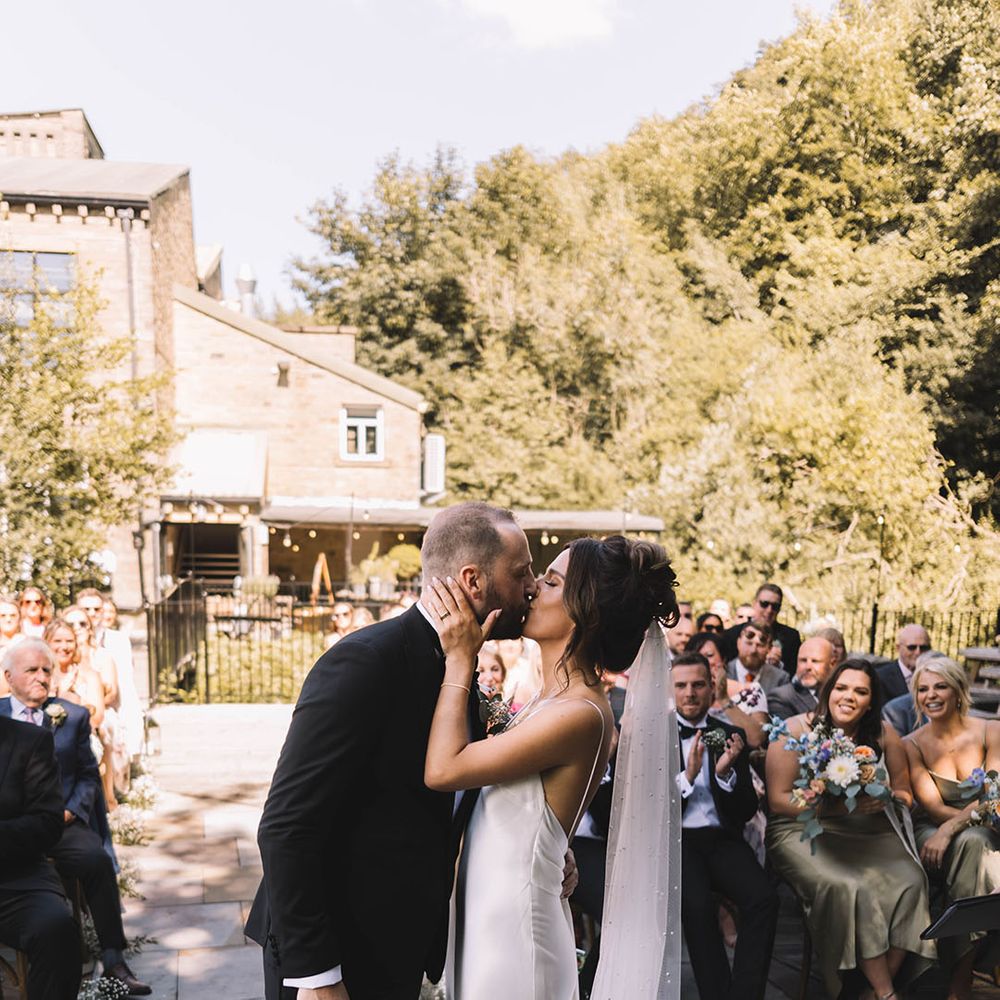 The bride and groom share their first kiss as a married couple 