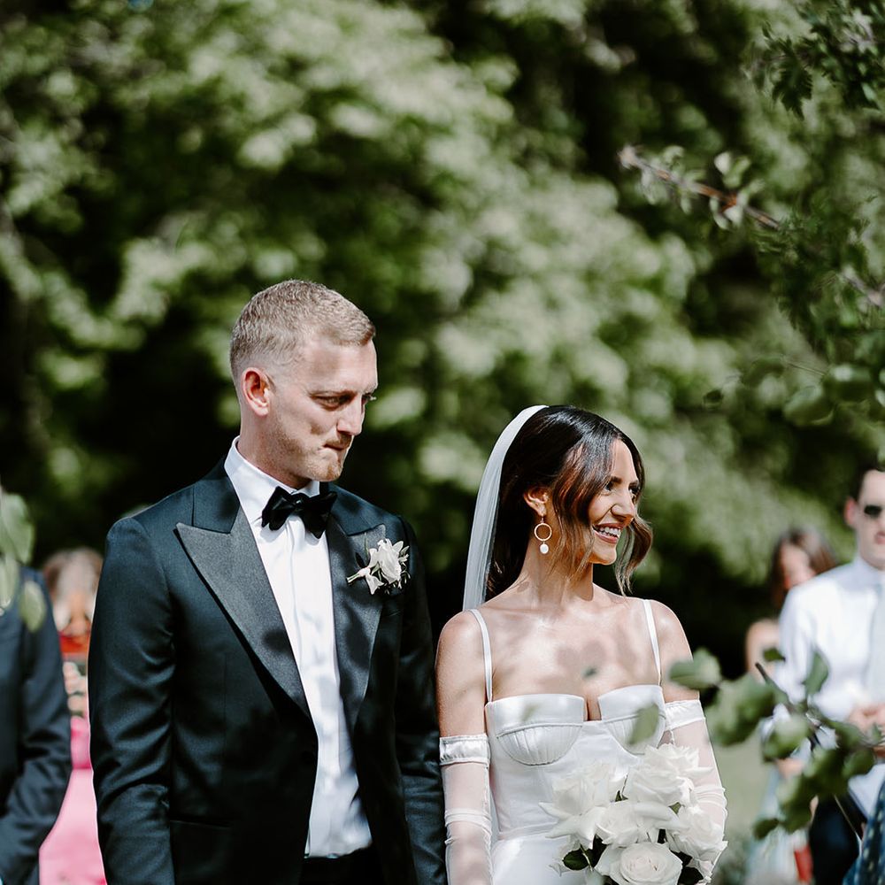 Monochrome chic wedding with the groom in a black tux and bride in satin wedding dress 