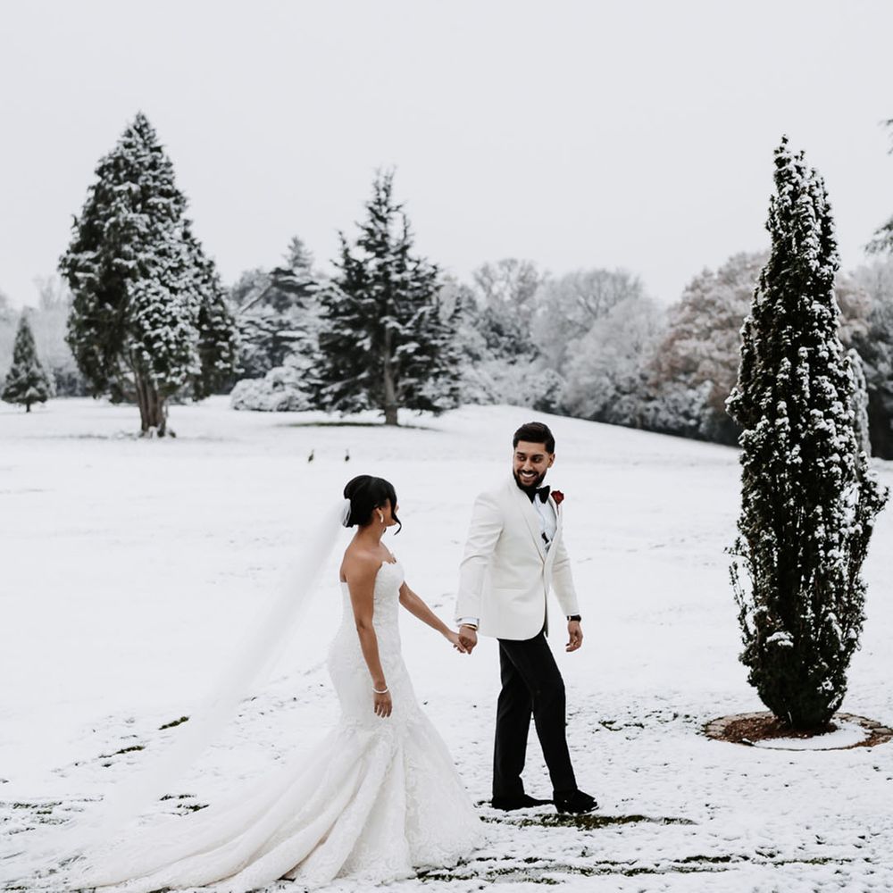 Winter wedding with the bride and groom walking around together in the snow 