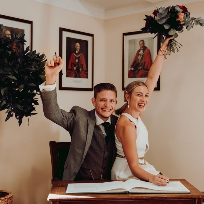 Bride and groom signing the register at intimate micro wedding 