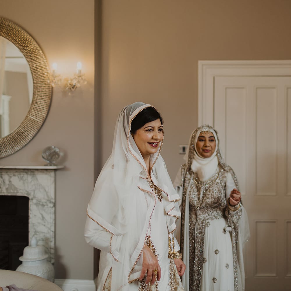 Mother of the bride in a ivory and gold sari on the wedding morning 